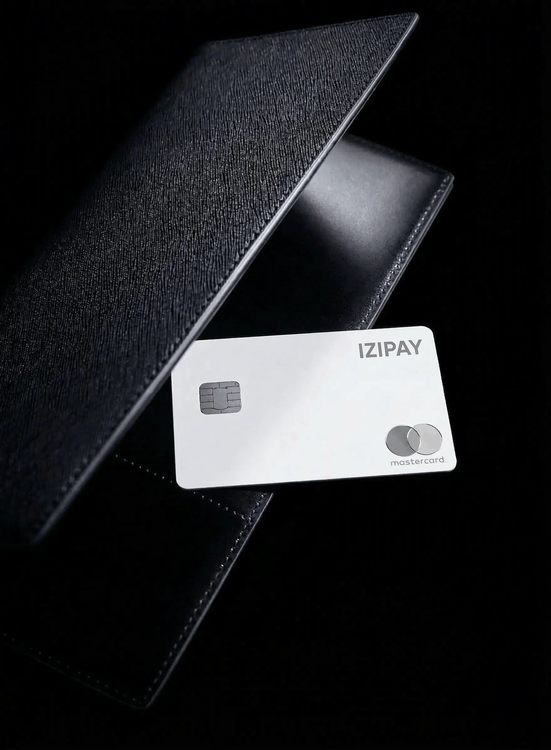 An iPhone is fanned out behind a neat stack of sleek, matte black physical IZIPAY payment cards featuring a silver diamond logo, fanned out on a light wood desk next to stylized subway icons for London, NYC, and Tokyo.